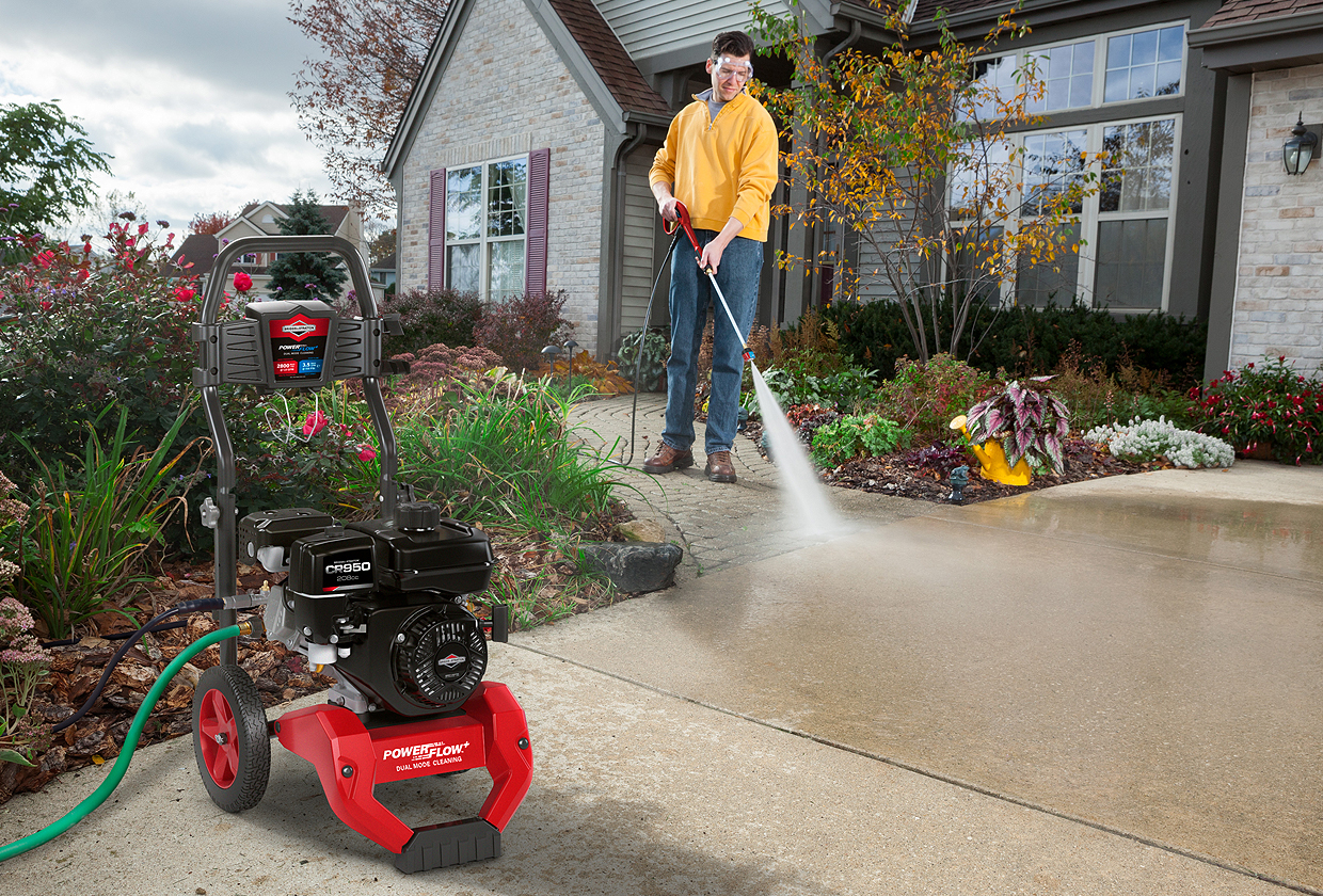 man cleaning concrete with pressure washer